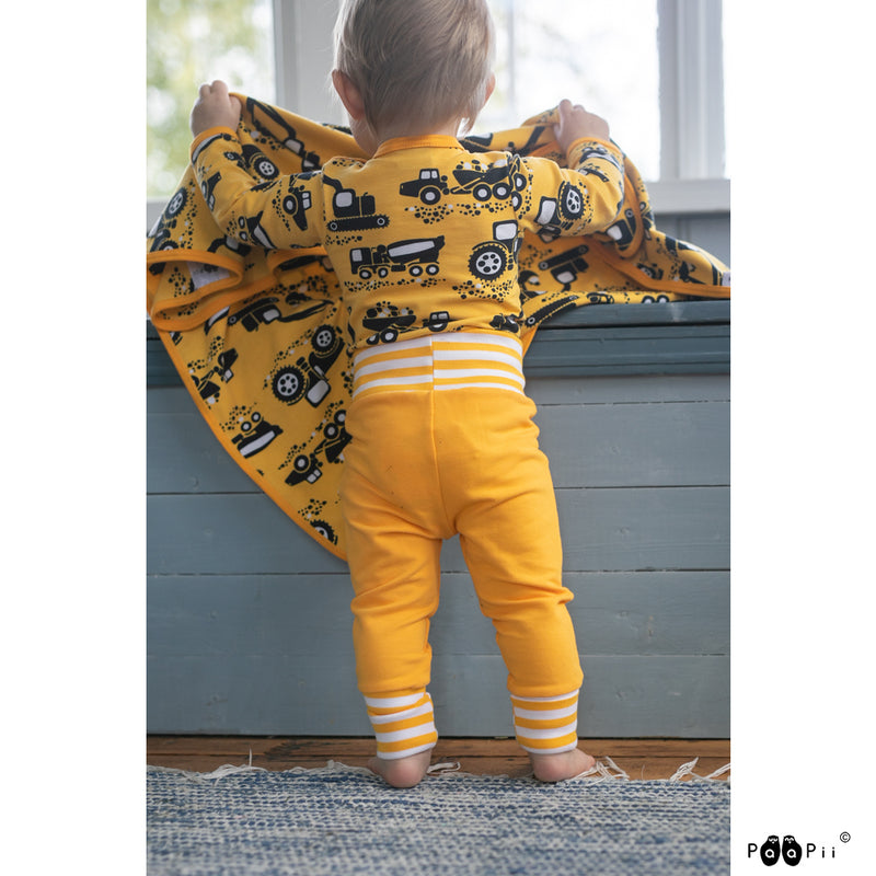 Baby wearing PaaPii Onesie with yellow Machines pattenr