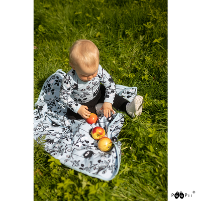 toddler sitting on PaaPii Siiri in the Swing Blue Baby Blanket in grass