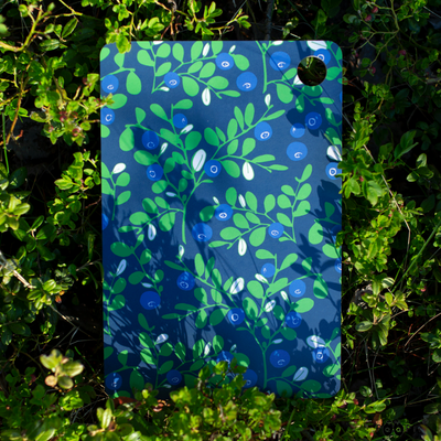 Paapii Blueberry Birch Cutting Board in berry bushes