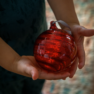 holding delicate Pentik Spiraali Glass Ball Ornament