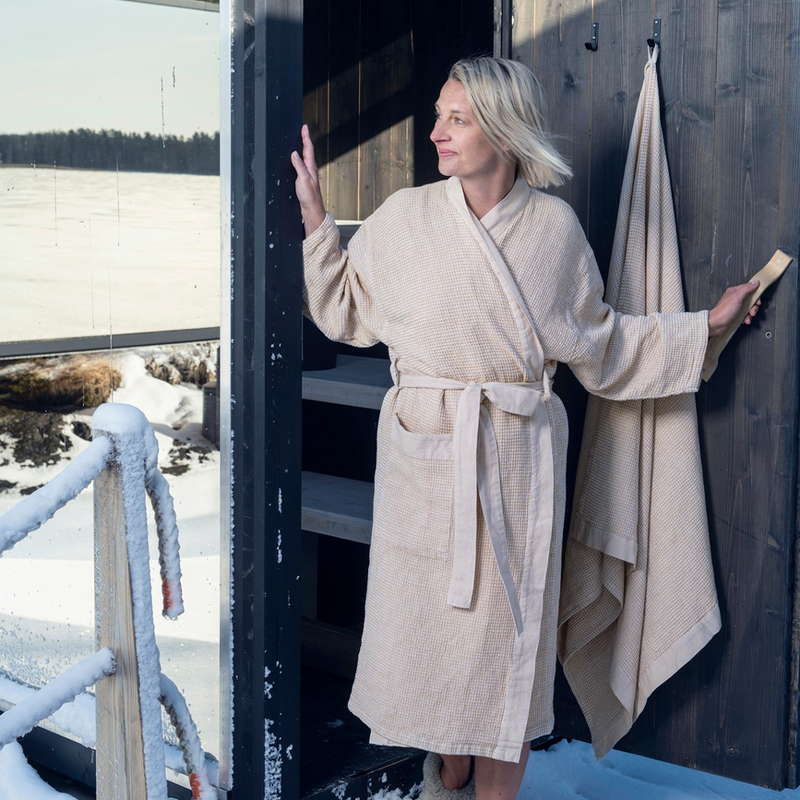 Woman walking out of sauna in bath robe