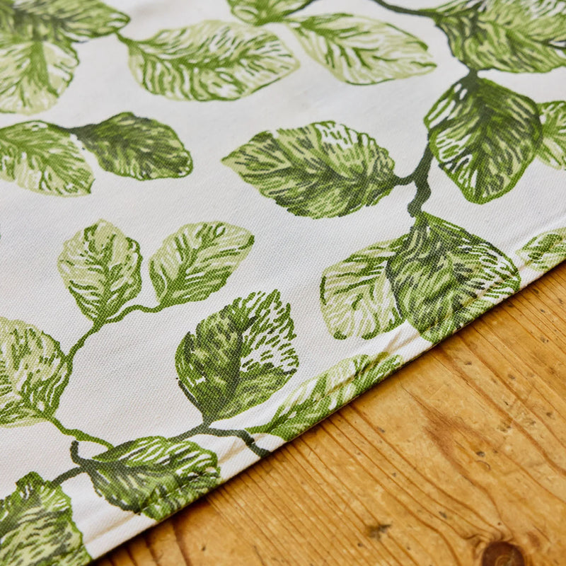 Fabric with green leaf pattern on a wooden surface