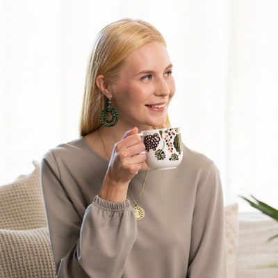 Woman drinking from Aarikka Puisto Rams in a Field Mug