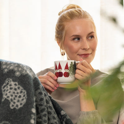 woman drinking out of Aarikka Puisto Tonttus in a Forest Mug