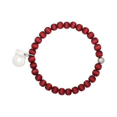 Red beaded bracelet with a silver tag on a white background