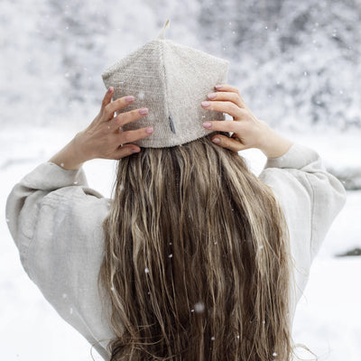 Person wearing a knit beanie in a snowy landscape
