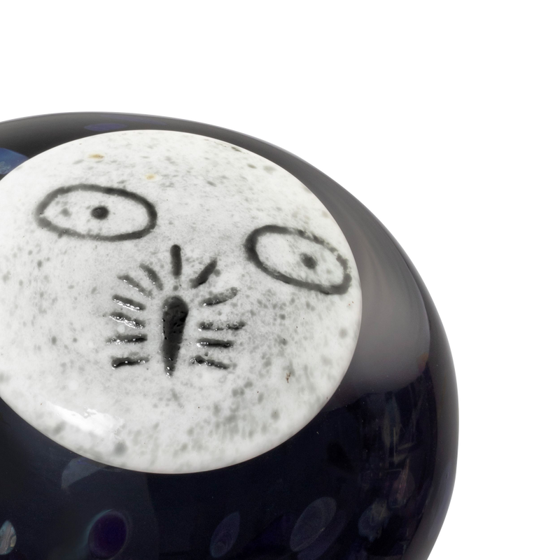 Close-up of a ceramic object with a face design on a white background