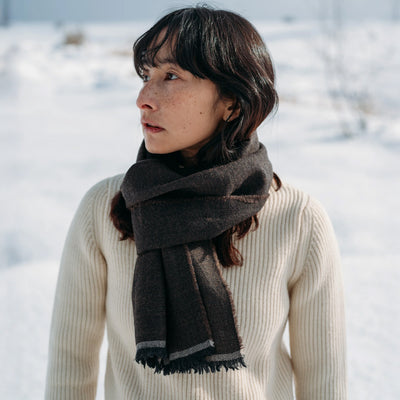 Woman wearing a dark brown scarf in a snowy landscape