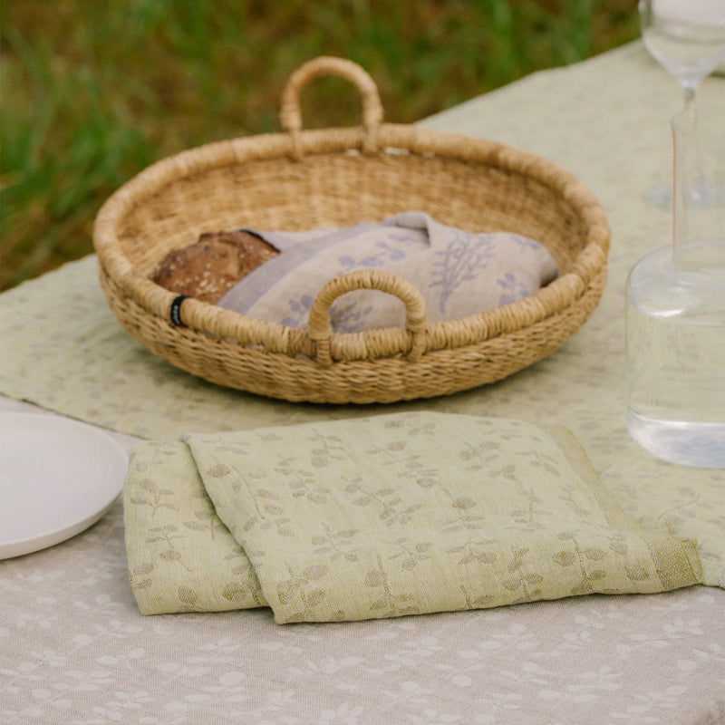 Woven basket with folded fabric on a table outdoors