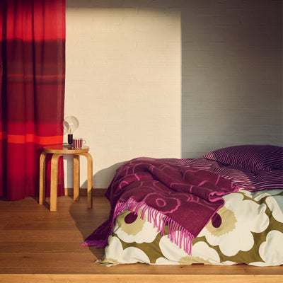 Bedroom with floral bedspread and red curtain