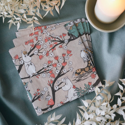 Set of four patterned napkins on a green surface with decorative elements.