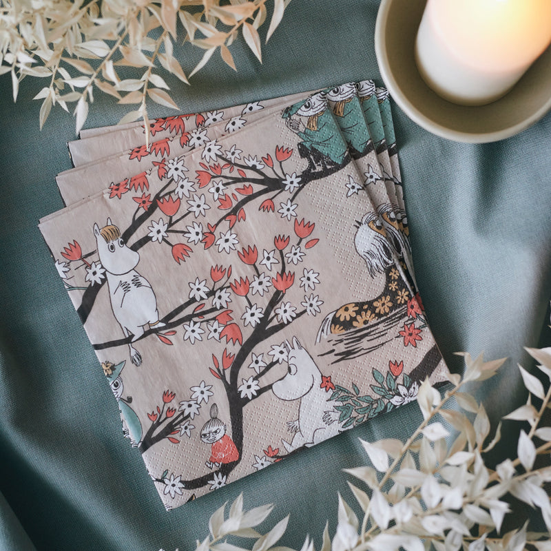 Set of four patterned napkins on a green surface with decorative elements.