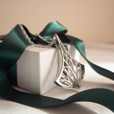 Lumoava Empress Necklace draped over white gift box with green ribbon