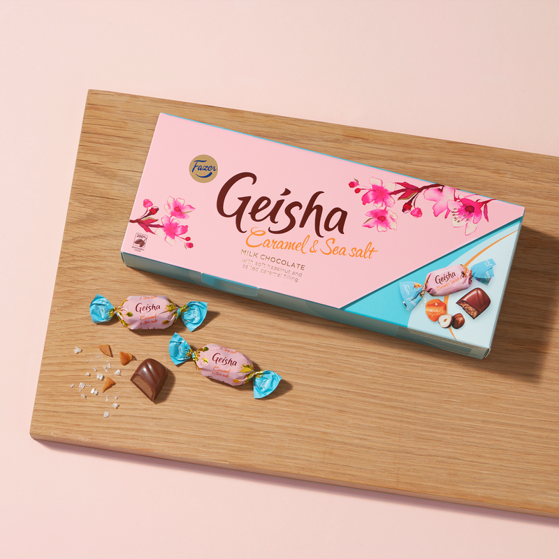 Fazer Geisha Caramel Sea Salt Milk Chocolates Box with one wrapped piece cut in half