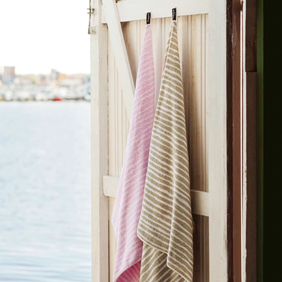 Finlayson Bath Towels hanging on open door next to water