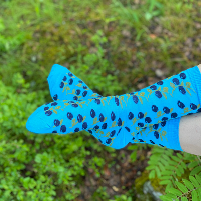 person with feet crossed wearing blueberry socks