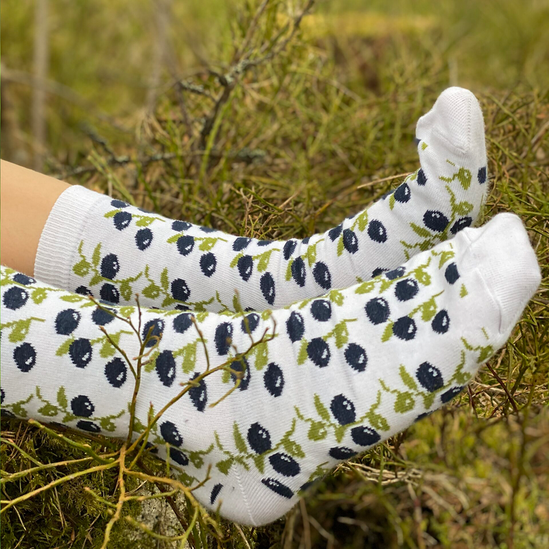 Person wearing blueberry white socks in grass