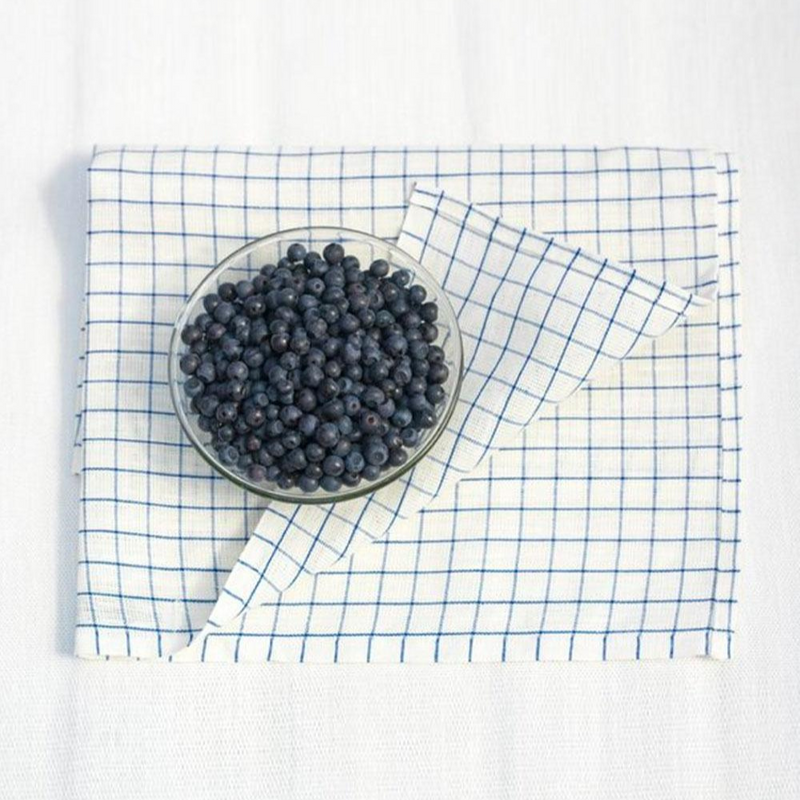 Folded Keittiöruutu blue striped towel with bowl of blueberries