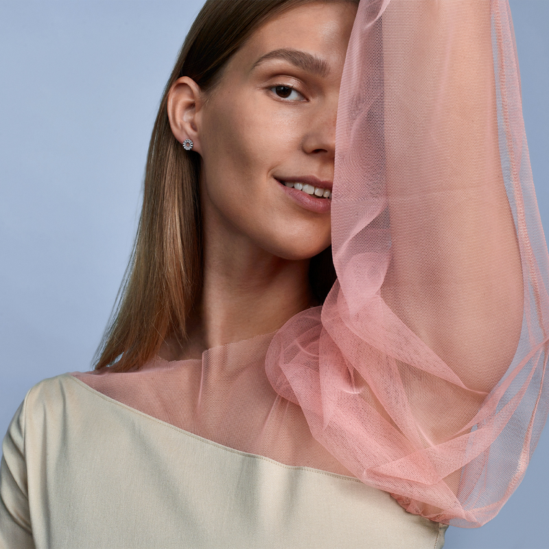 smiling woman wearing circle of light earring with dress