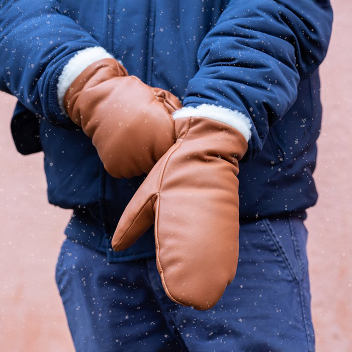 Person in blue jacket and pants wearing cognac leather gloves