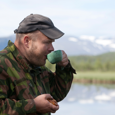Man in camo jaacket sipping out of Kupilka classic cup