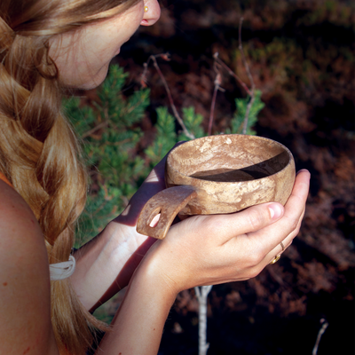 Person holding Kupilka cup in woods
