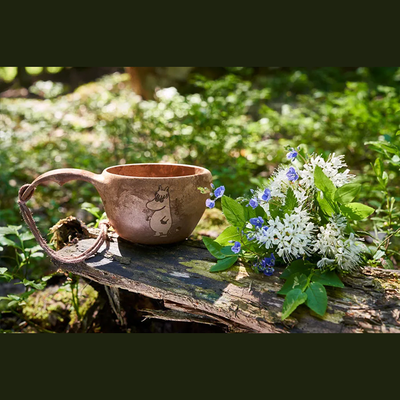 Kupilka Snorkmaiden Classic Cup sitting on log in woods