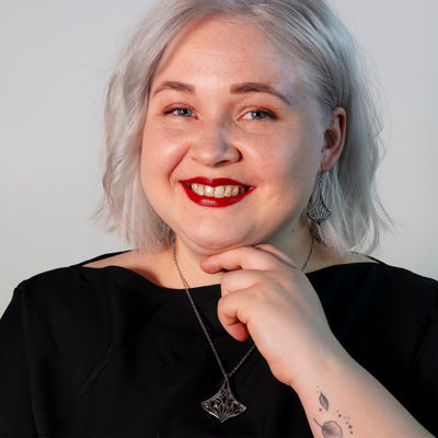 Smiling person in black top posing for camera with Lumoava Empress Necklace
