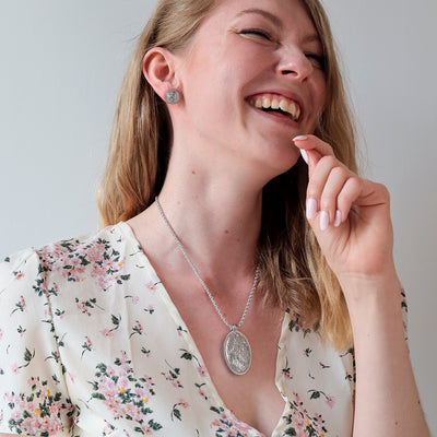 Woman laughing while wearing Lumoava Primavera jewelry