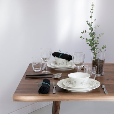 Two place settings of Saaga dinnerware on table