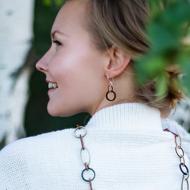Woman in white top wearing Valona Mini Halo Birch Earrings, Natural/Black