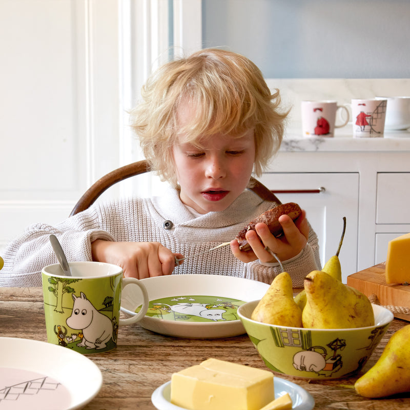 child eating breakfast using moomin plate