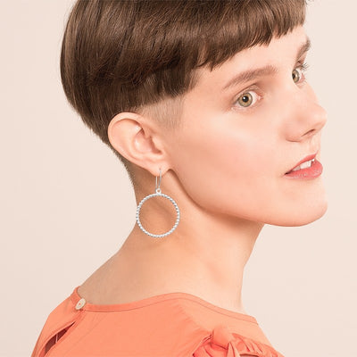 brown haired model wearing circle of light earring