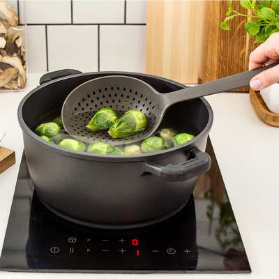 person using GastroMax Colander Spoon to strain brussel sprouts