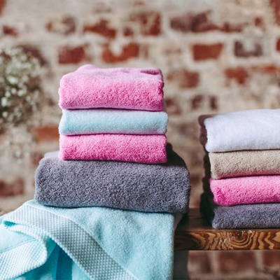 Assorted colors of Finlayson Hali Bath Towels folded and stacked