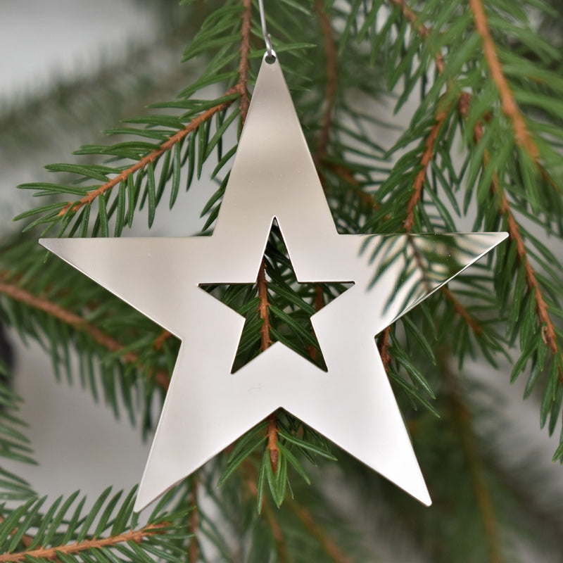 Pohjolan Helmi Shining Star Ornament hanging in tree
