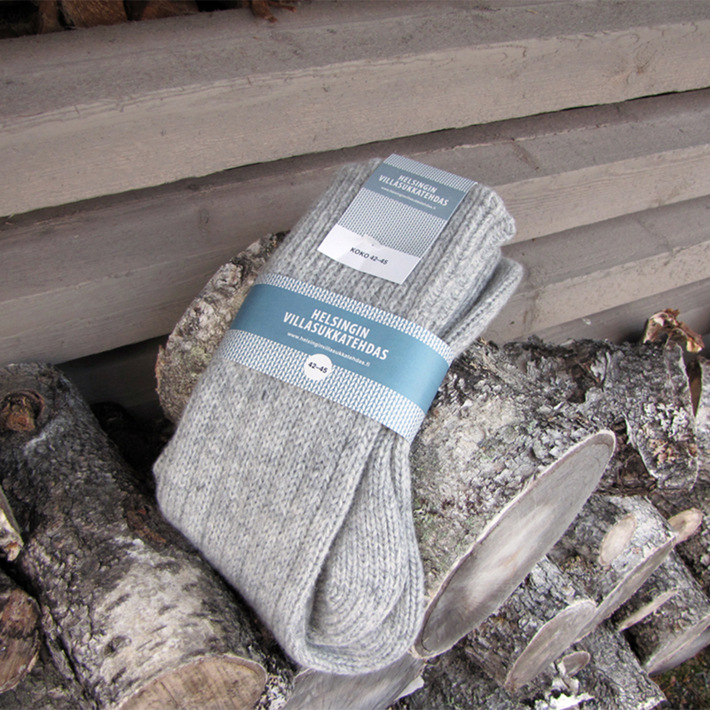 Helsinki Woolen Socks, Lichen Grey laying on wood pile