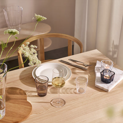 Filled iittala Essence White Wine Glass with place setting of dinnerware