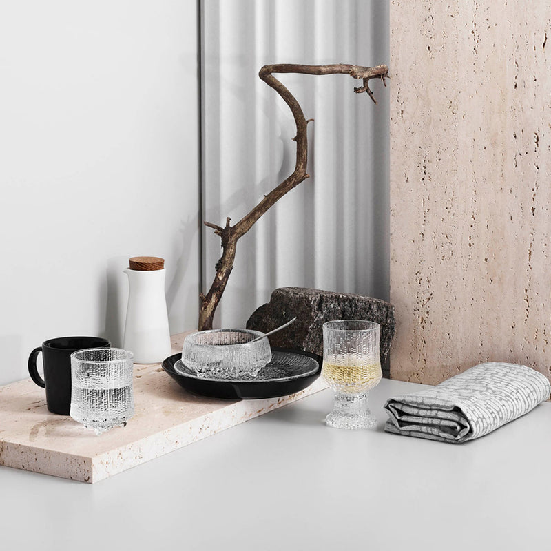 Table setting of iittala glassware with teema black dinnerware accent