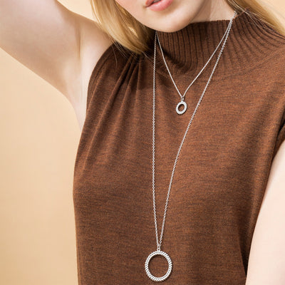 model in brown top wearing circle of light necklaces