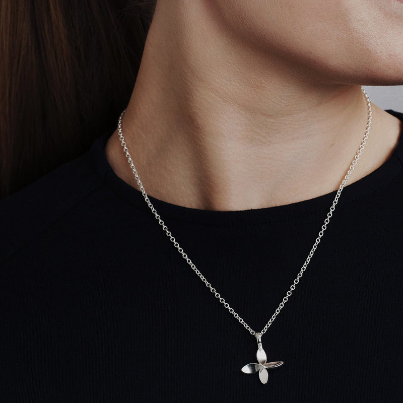 closeup of person in black shirt wearing cross of friendship necklace