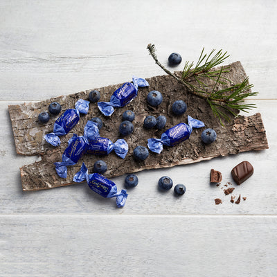 Individual pieces of blueberry truffle candy on birchbark