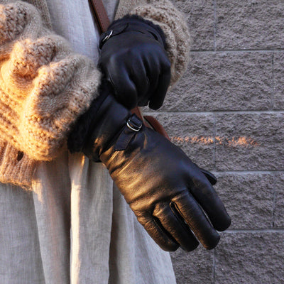 Women in brown cardigan wearing black leather gloves