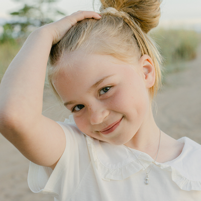 Small smiling child wearing Lumoava Moomin Little My Necklace