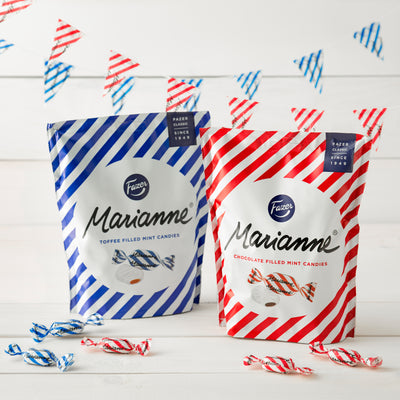 Bags of Marianne candy on table with party decoration in background