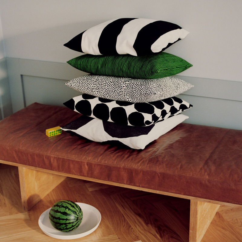 5 Marimekko cushion covers stacked on bench