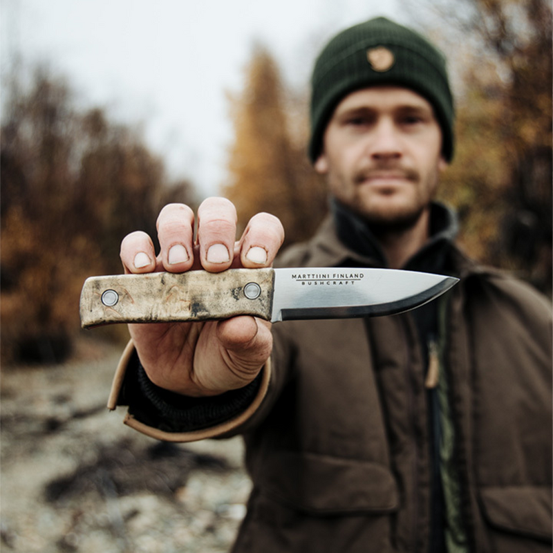Man holding Marttiini Tundra GR Knife in woods
