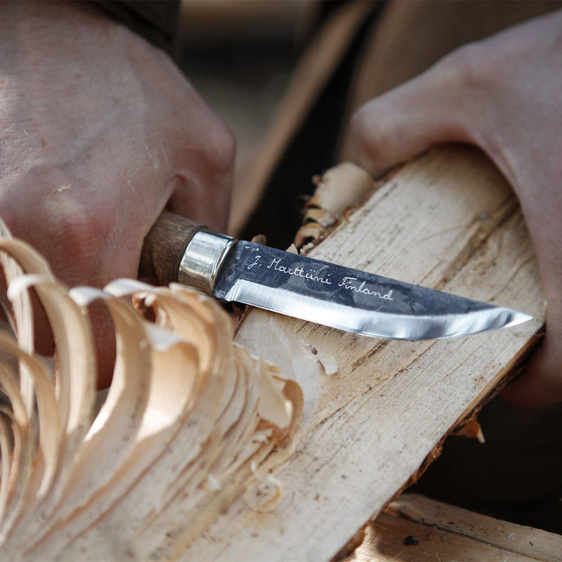 Using Marttiini Lumberjack Carbon Knife to shave kindling from firewood