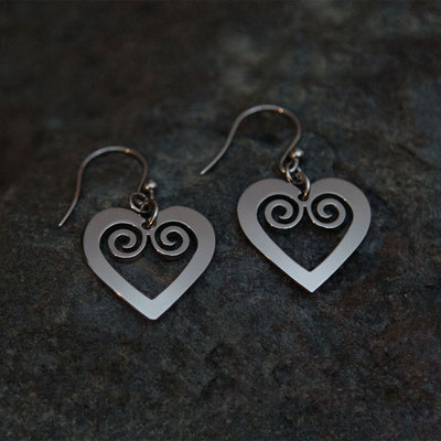 Pohjolan Helmi Curved Heart Earrings placed on rock