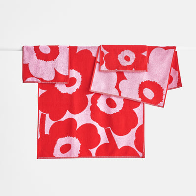 Display group of Marimekko Unikko pink/red Bath Towels hanging up